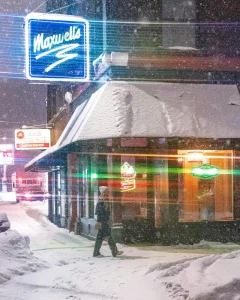 outdoor lighted store sign in a heavy snow