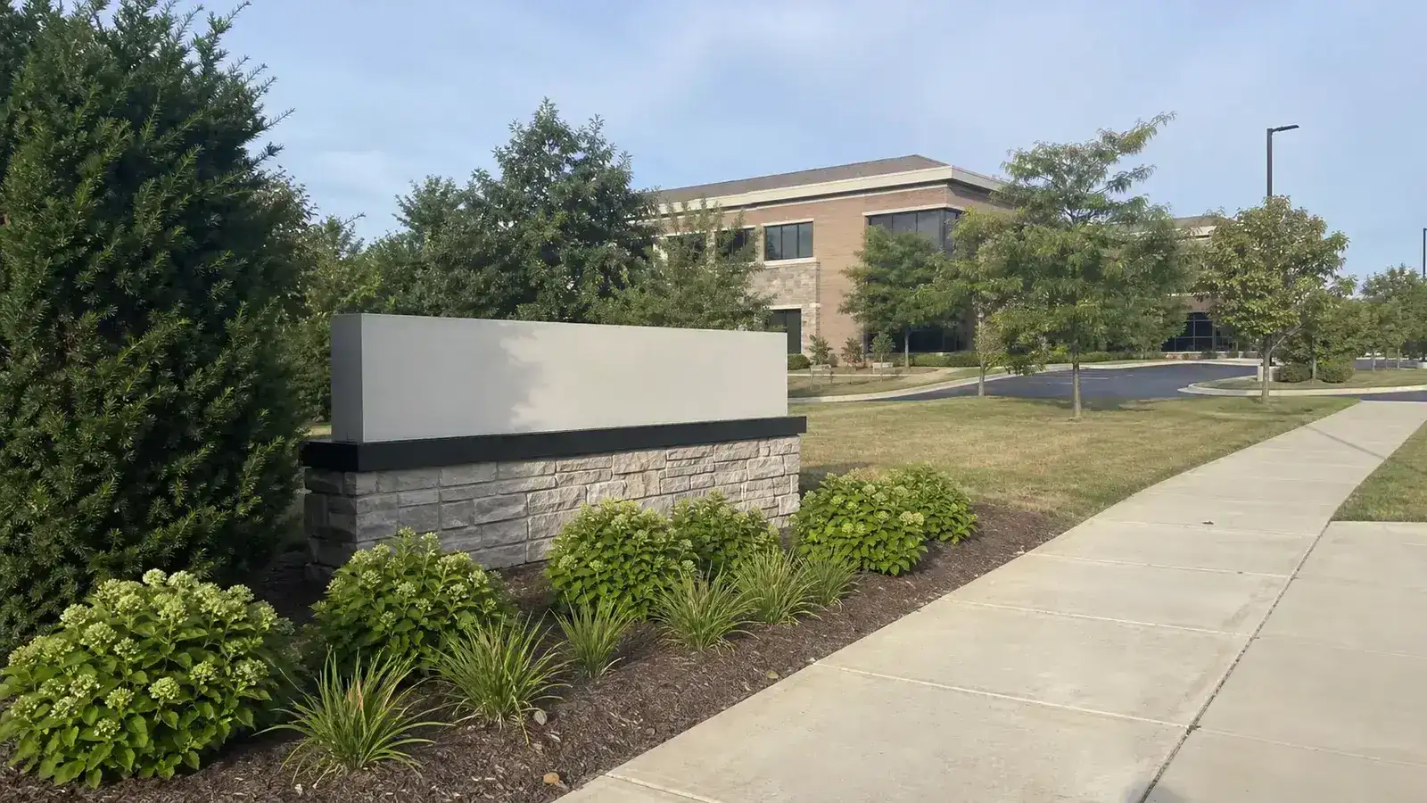 Low stone monument sign at a landscaped professional office campus